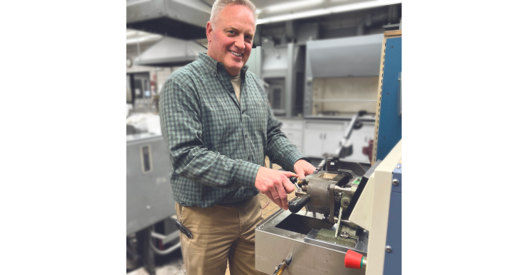 A man works at a machine in a manufacturing plant