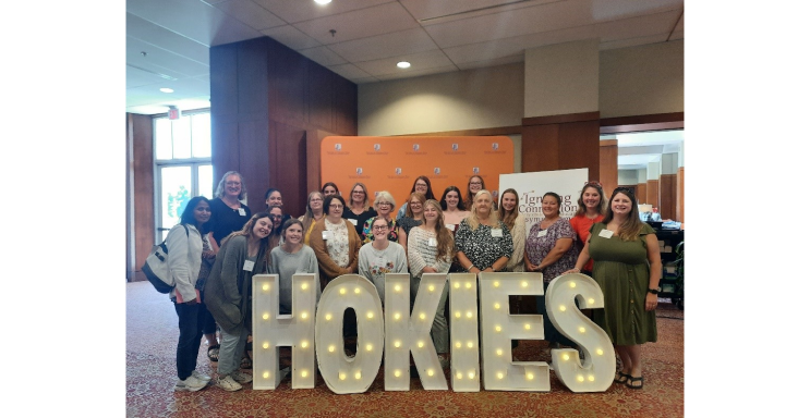 group picture in front a sign for the Hokies